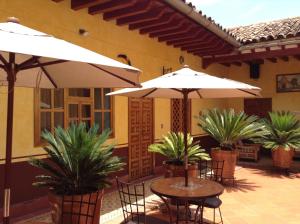帕茨库卡罗波萨达德拉萨鲁德酒店的一个带桌椅和遮阳伞的庭院
