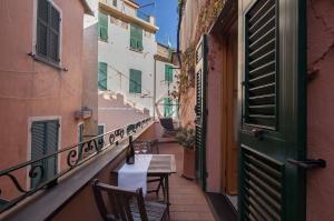 蒙特罗索阿尔马雷Appartamento Piccolo Principe的阳台的小巷,配有桌椅