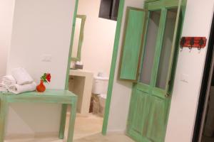图卢姆波萨达蓬彼德拉海滩酒店的浴室位于厕所旁,设有绿门