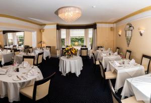 北沃尔舍姆比奇伍德酒店的一间设有白色桌椅的用餐室