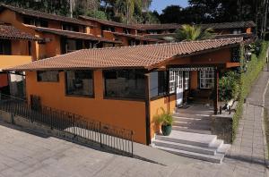 帕拉蒂Pousada Do Forte的一座橙色的小建筑,前面设有楼梯