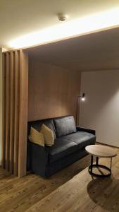 圣卡夏诺福赛里斯酒店的客厅配有一张黑色沙发,设有一张桌子