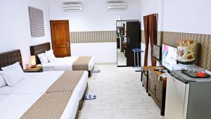 日惹日惹必玩之家旅馆的酒店客房设有两张床和一台平面电视。