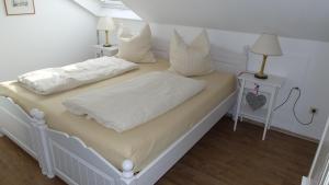 奥格斯堡奥古斯塔逃遁公寓的一间卧室配有两张带白色床单和枕头的床。