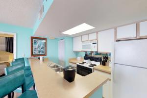 基韦斯特Sunrise Suites Catalina Suite #311的厨房拥有蓝色的墙壁和白色的冰箱。