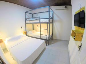 菲格雷多总统镇Hostel da Milla的一间卧室配有双层床和电视