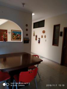 瓜亚基尔Casa Canelos的一间带木桌和红色椅子的用餐室