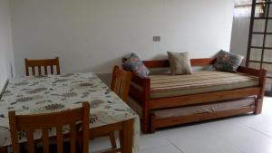 卡拉瓜塔图巴Chalés Flamboyant的卧室配有一张床和一张桌子及椅子
