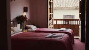 库斯科Casona Santa Catalina Cusco的酒店客房设有两张床和窗户。