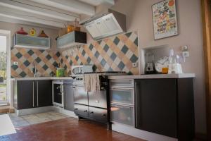 LandécourtLes Ruchers d'Emile的厨房配有不锈钢用具和黑色橱柜