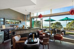 新普利茅斯新普利茅斯海滨千禧酒店的餐厅设有酒吧,配有桌椅