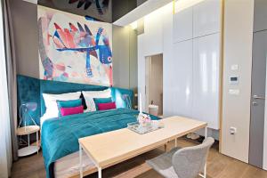 萨拉热窝FERHADIJA Apartments by Nejra的一间卧室配有一张蓝色的床和一张桌子