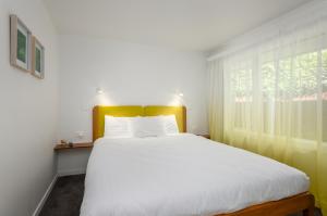 基督城The Adelphi的卧室设有一张白色大床和一扇窗户。