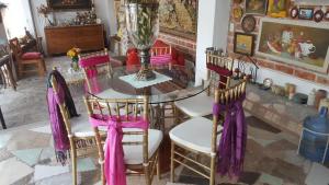 Santa Rosa de JáureguiLa Casona Azul Bed n Breakfast的一间用餐室,配有一张桌子和椅子,并拥有紫色的弓