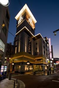 大阪Hotel Sen (Adult Only)的一座高大的建筑,上面有钟