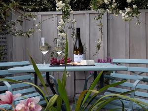 玛普瓦Mapua Studio Quality Accommodation的一张带酒杯和葡萄酒瓶的蓝色桌子