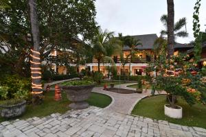 沙努尔Palm Garden Hotel的一座种有树木的庭院和一座建筑