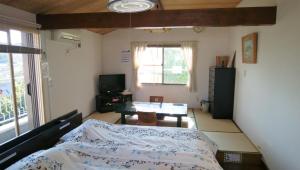 镰仓市镰仓民宿的一间卧室配有一张床、一张桌子和一个窗户。