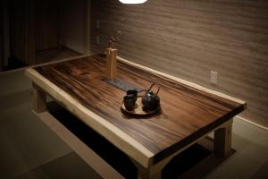 大阪Bijou Suites Will的一张木桌,上面有两根蜡烛