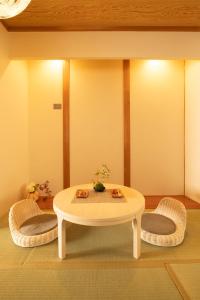 大阪Bijou Suites Will的客厅配有桌子和两把椅子