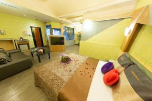 万里区金涌泉温泉汽车旅馆的一间设有床铺和客厅的房间