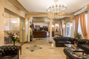 罗马罗莎别墅酒店的大型客厅配有皮革家具和吊灯