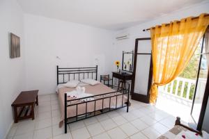 里科索翁凯法利尼亚海滩简易别墅酒店的一间卧室配有一张床、一张书桌和一个窗户。