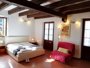坎诺比奥Casa Cannobio的一间卧室配有一张床和一张红色椅子