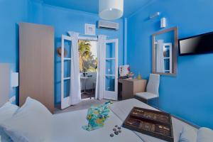卡马利海神海滩酒店的蓝色的客房设有床和浴室。