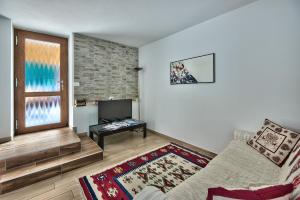 莫尔韦诺Genzianella Molveno-Andalo的带沙发和电视的客厅