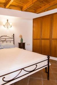 MirsíniAgrilos Οlive Τree Αpartment的一间卧室配有一张大床和一个木制橱柜
