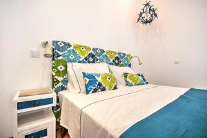 法鲁Blue Barqueta Studio的一间卧室配有一张带蓝色和绿色枕头的床
