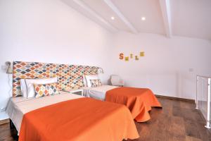 法鲁Terrace Barqueta Studio的一间带两张床和橙色毯子的卧室