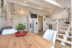 法鲁Terrace Barqueta Studio的厨房以及带木桌和白色家电的用餐室。