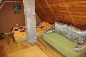 兹拉蒂博尔Vila Zlatibor Tornik的客房内设有两张床,铺有木地板,拥有天花板。