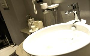 基瓦索Hotel Chivasso的浴室配有白色水槽和卫生间。