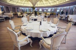 沃罗涅什维特亚克夫精品酒店的一间设有白色桌椅的大型用餐室