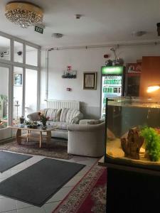 布达佩斯Népliget Hotel的带沙发和鱼缸的客厅