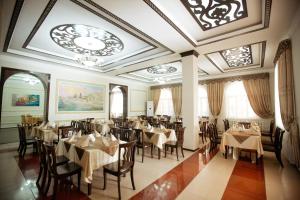 希瓦希瓦亚洲大酒店的一间带桌椅和天花板的餐厅