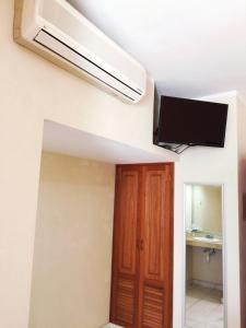 坎佩切Hotel Villa Campeche的客房设有吊扇和电视。