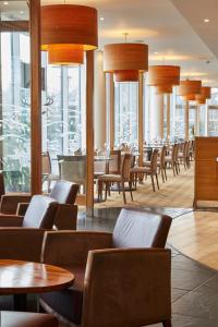 普里茅斯普利茅斯未来旅馆的餐厅设有桌椅和窗户。