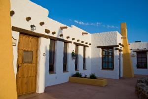 Los AlbaricoquesOlivares Rural的白色的建筑,设有木门和窗户