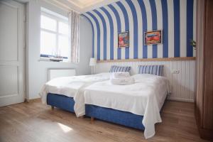 乌斯特卡Mistral Ustka的一间卧室配有一张带蓝白色条纹墙的床