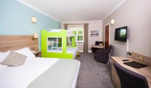 恩尼斯特利斯西县会议和休闲中心酒店的酒店客房配有一张床和一张带椅子的书桌