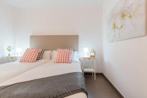 科尔内拉德罗布雷加特Apartamentos Cornellalux 2的一间卧室配有一张带红色和白色枕头的大床