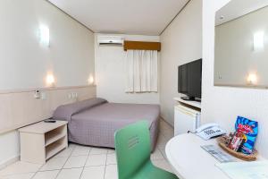 阿雷格里港Hotel Expressinho Aeroporto的小房间设有床和电视