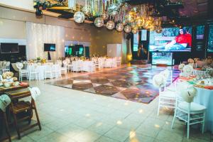 圣罗莎拉凯姆皮纳俱乐部酒店& Spa的一个带白色椅子的宴会厅和舞池