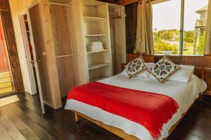 何塞伊格纳西奥BDL Beach Design Loft One的一间卧室配有一张带红色毯子的床和窗户。
