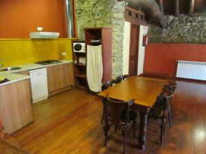 El SerratCan Bonada的厨房铺有木地板,配有木桌。
