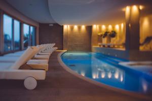西尔米奥奈Olivi Hotel & Natural Spa的一座带白色躺椅的酒店游泳池